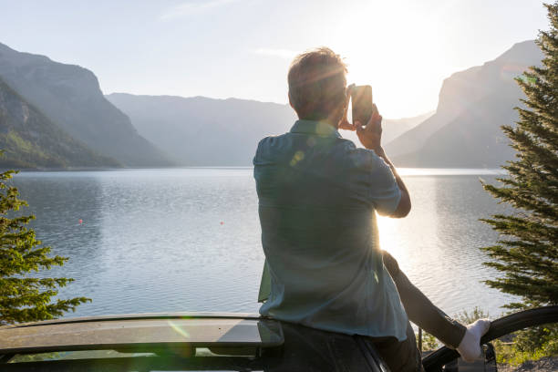 He takes smart phone pic of view. Lake Minnewanka, Banff NP, Alberta